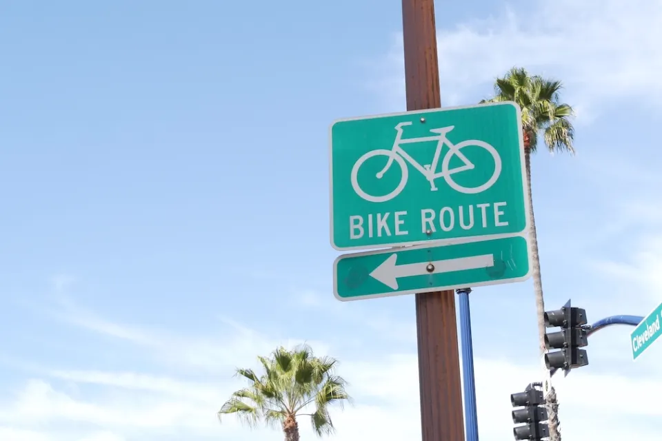 Close-up of green and white Bike Route sign with arrow in California.